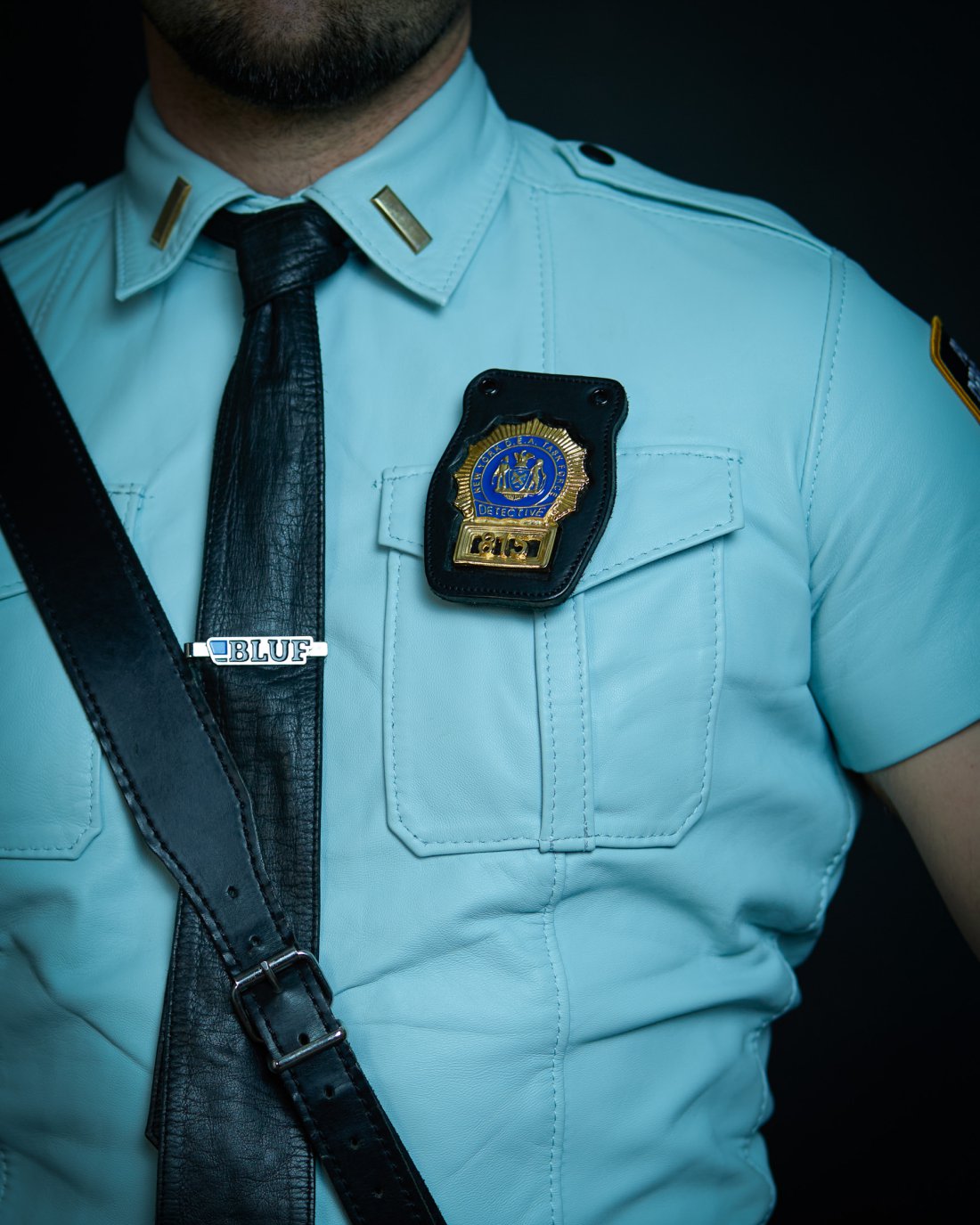 Light blue short-sleeved leather shirt with epaulets and a collar